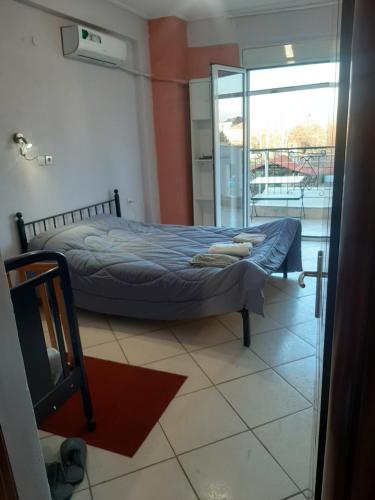 Schlafzimmer mit einem Bett und einer Glastür in der Unterkunft Mεζονέτα in Kardítsa