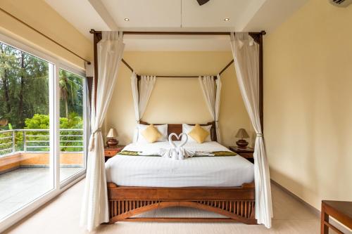 a bedroom with a canopy bed and a balcony at Little Sunshine Boutique Beach Resort & Spa in Ko Chang