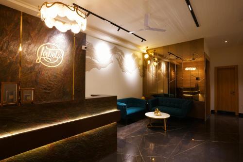 un vestíbulo con un bar con sillas azules y una mesa en Labels Hotel, en Nagpur
