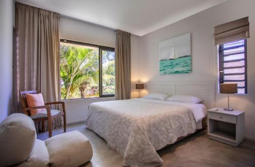 a bedroom with a bed and a large window at Beach Villa Poema in Centre de Flacq