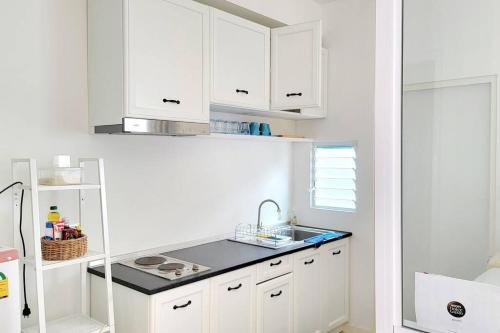 uma cozinha com armários brancos e um lavatório em TownHouse For Rent em Ban Thap Nang
