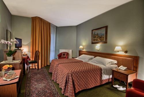 a hotel room with a bed and a living room at Hotel Petrarca Terme in Montegrotto Terme