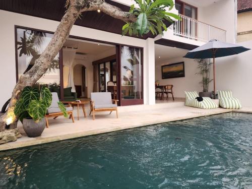 a villa with a swimming pool and a house at Motama Villa in Ubud