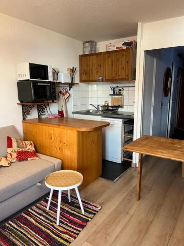 un salon avec un canapé et une cuisine dans l'établissement Appartement les deux alpes+parking couvert, à Les Deux Alpes