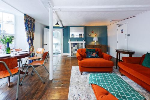 a living room with orange furniture and a table at Northern Belle four Bedroom Apartment in Margate