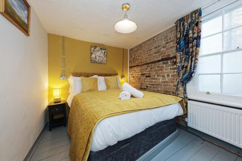 a bedroom with a bed and a brick wall at Northern Belle four Bedroom Apartment in Margate