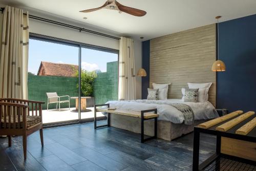 a bedroom with a large bed and a large window at Nosy Manga - Hotel Ivato Airport in Antananarivo