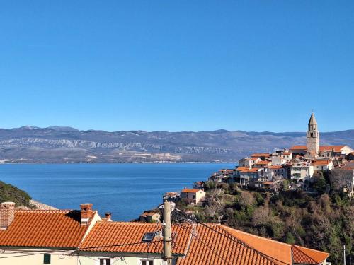 a town on a hill with a large body of water at Apartmani Marin1 in Vrbnik