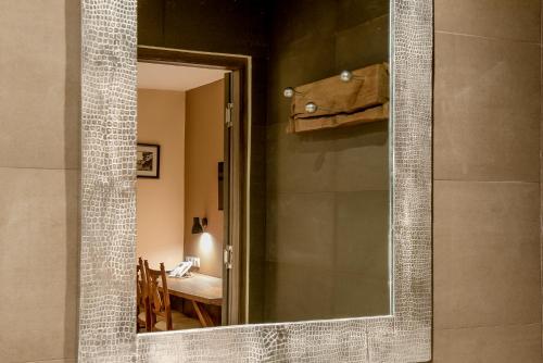 a mirror in a bathroom with a table in a room at Nosy Manga - Hotel Ivato Airport in Antananarivo