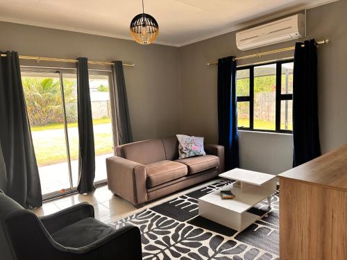 a living room with a couch and a table at WeMukelekile (you are welcome) in Lobamba