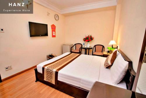 a hotel room with a bed and a tv at HANZ Thanh Thu Hotel in Ho Chi Minh City