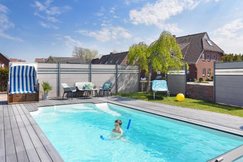 a little girl swimming in a swimming pool at Haus Strandkorb Bensersiel in Bensersiel