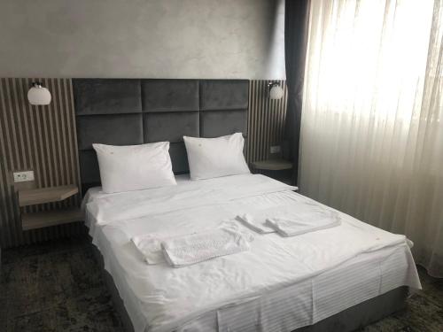 a bedroom with a white bed with towels on it at Sub Cetate in Râşnov