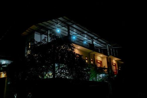 a building with blue lights on top of it at night at Emerald Home Stay in Anuradhapura
