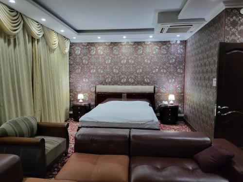 seoul hotel في شيمكنت: غرفة نوم بسرير واريكة