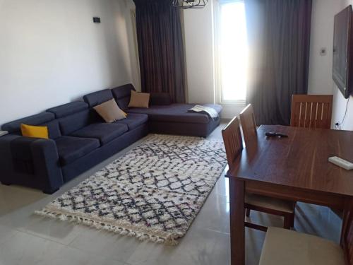 uma sala de estar com um sofá azul e uma mesa em Maison de repos em New cairo
