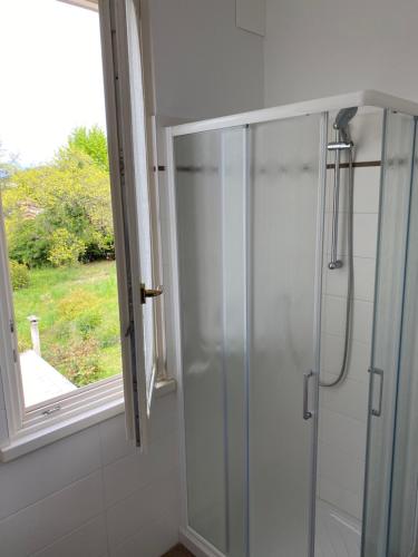 La salle de bains est pourvue d'une douche en verre et d'une fenêtre. dans l'établissement Cozy Escape in Bellagio, à Bellagio