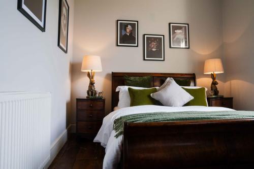 um quarto com uma cama e quadros na parede em St Anne's Manor - Luxury Villa with Hot Tub em Torquay
