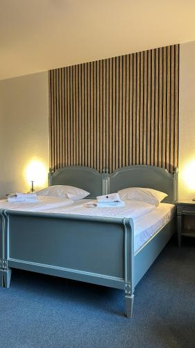 uma cama grande num quarto com duas lâmpadas em Gästehaus Weserblick am Weser-Sandstrand em Berne