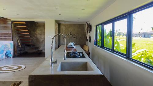 a kitchen with a sink and a large window at Ocean Villa - Joshua District in Tabanan
