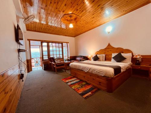 a bedroom with a bed and a table in a room at Manali Heritage Hotel in Manāli