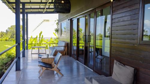 a patio with chairs and a table on a house at Ocean Villa - Joshua District in Tabanan