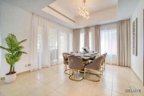 uma sala de jantar com mesa e cadeiras em Luxury 3BR Villa with Assistant Room at Alvorada 4 Arabian Ranches by Deluxe Holiday Homes no Dubai