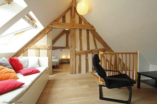 ein Wohnzimmer mit einer weißen Couch und einem Stuhl in der Unterkunft Havre de paix proche de Bagnoles de l'Orne in Saint-Michel-des-Andaines