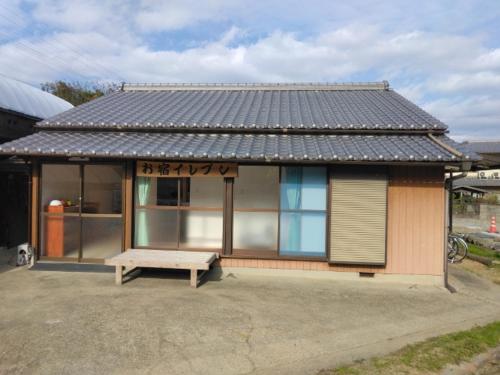 ein kleines Haus mit einer Bank davor in der Unterkunft お宿イレブン 
