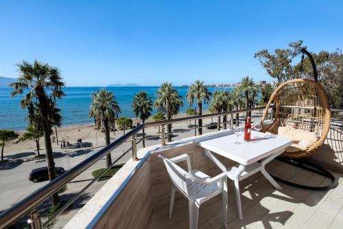 a balcony with a table and chairs and the beach at Jimi Apartments 2 in Vlorë