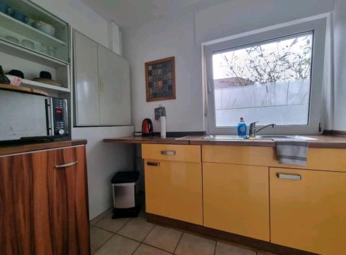 cocina con fregadero y ventana en Fewo Neuruppin Einliegerwohnung, en Neuruppin