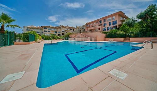 une grande piscine bleue avec des bâtiments en arrière-plan dans l'établissement Sunset-Apartment St-Tropez-swimming pool-parking, à Saint-Tropez