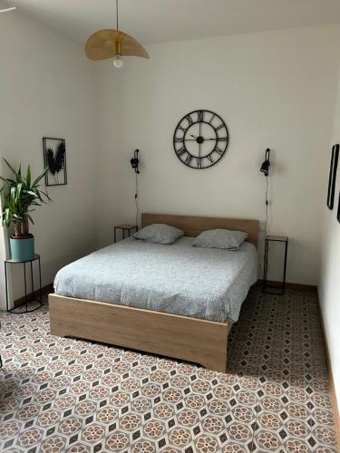 a bedroom with a bed and a clock on the wall at notre dame des anges in Lurs