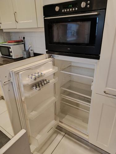 a kitchen with an empty refrigerator with a microwave at Liège centre 13 Quai Godefroid Kurth POUR 2 PERS à 25 min gare Guillemins in Liège