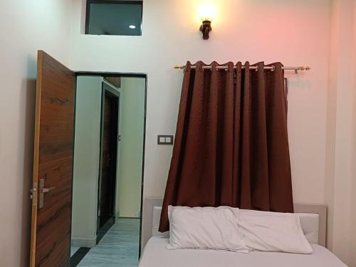 a bedroom with a bed with a curtain and a mirror at Hotel Raj 2 KM from Janana Hospital and 1 KM from MDS University in Ajmer