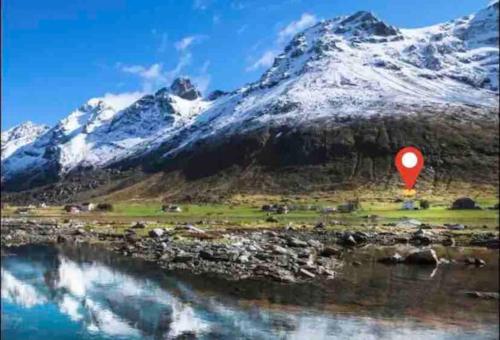 a red balloon in front of a snow covered mountain at Lofoten Fjord Apartment - Kvalvika Beach & Ryten in Skjelfjord