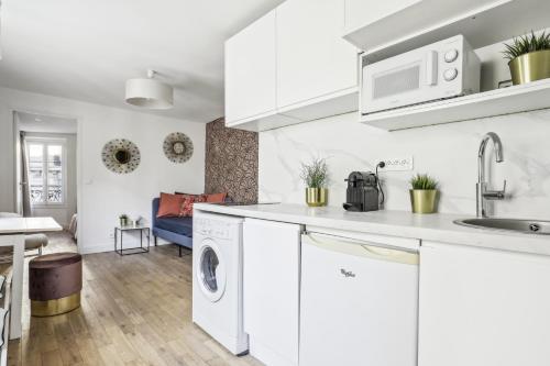 - une cuisine blanche avec lave-linge et sèche-linge dans l'établissement Luxury apartment near Le Marais, à Paris