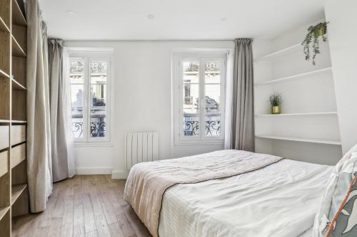 une chambre blanche avec un lit et deux fenêtres dans l'établissement Luxury apartment near Le Marais, à Paris