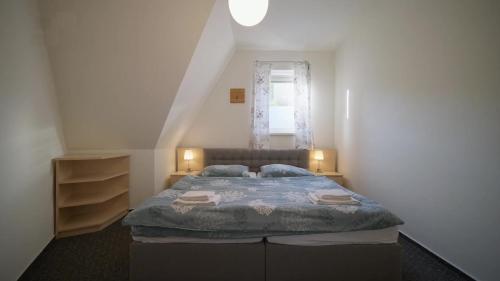 a bedroom with a large bed with a window at Vila Anna Wellness in Halenkov