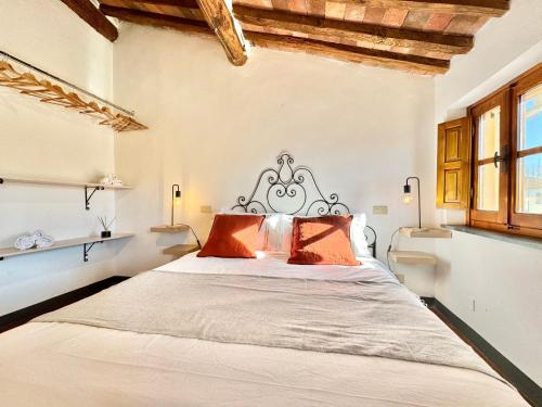 una camera da letto con un grande letto con cuscini arancioni di FRONTE MURA LUCCA - Parcheggio - WiFi Il CORTIGIANO a Lucca