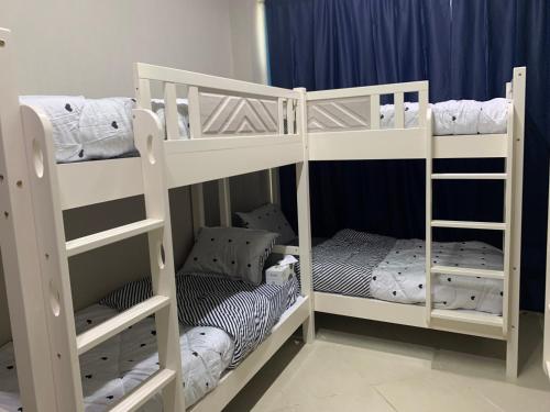 two white bunk beds in a room at DXB HOSTEL Near ADCB Metro Station in Dubai