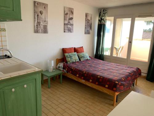 - une petite chambre avec un lit dans une cuisine dans l'établissement Studio Naturiste BIRD Port Soleil 442, au Cap d'Agde