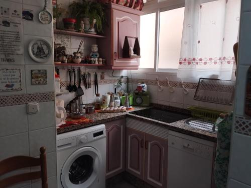 a small kitchen with a washing machine in it at La Casa de La Abuela Rosy in Málaga