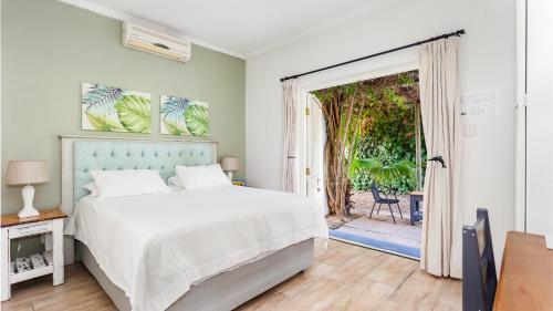 a bedroom with a bed and a door to a patio at Lady Loch Country House in Wellington