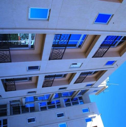 Blick auf ein Gebäude mit blauen Fenstern in der Unterkunft Armah International Hotel in Aksum