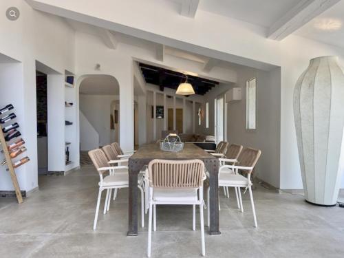 a dining room with a table and chairs and surfboards at Villa Ormarine, vue exceptionnelle sur la baie de Cannes et le Mercantour in Les Adrets de l'Esterel