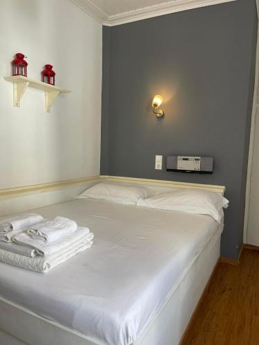 a white bed with towels on it in a room at Piteoussa Plus Hydra in Hydra