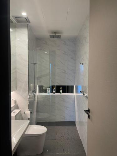 a bathroom with a toilet and a glass shower at Penang Amazing SeaView Private Lift 梹城富人区绝美海景公寓私人电梯 in Tanjong Tokong