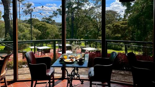 a table with a plate of food on a balcony at Karriview in Gracetown