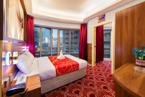 ドバイにあるTanha Hotelのベッドと大きな窓が備わるホテルルームです。